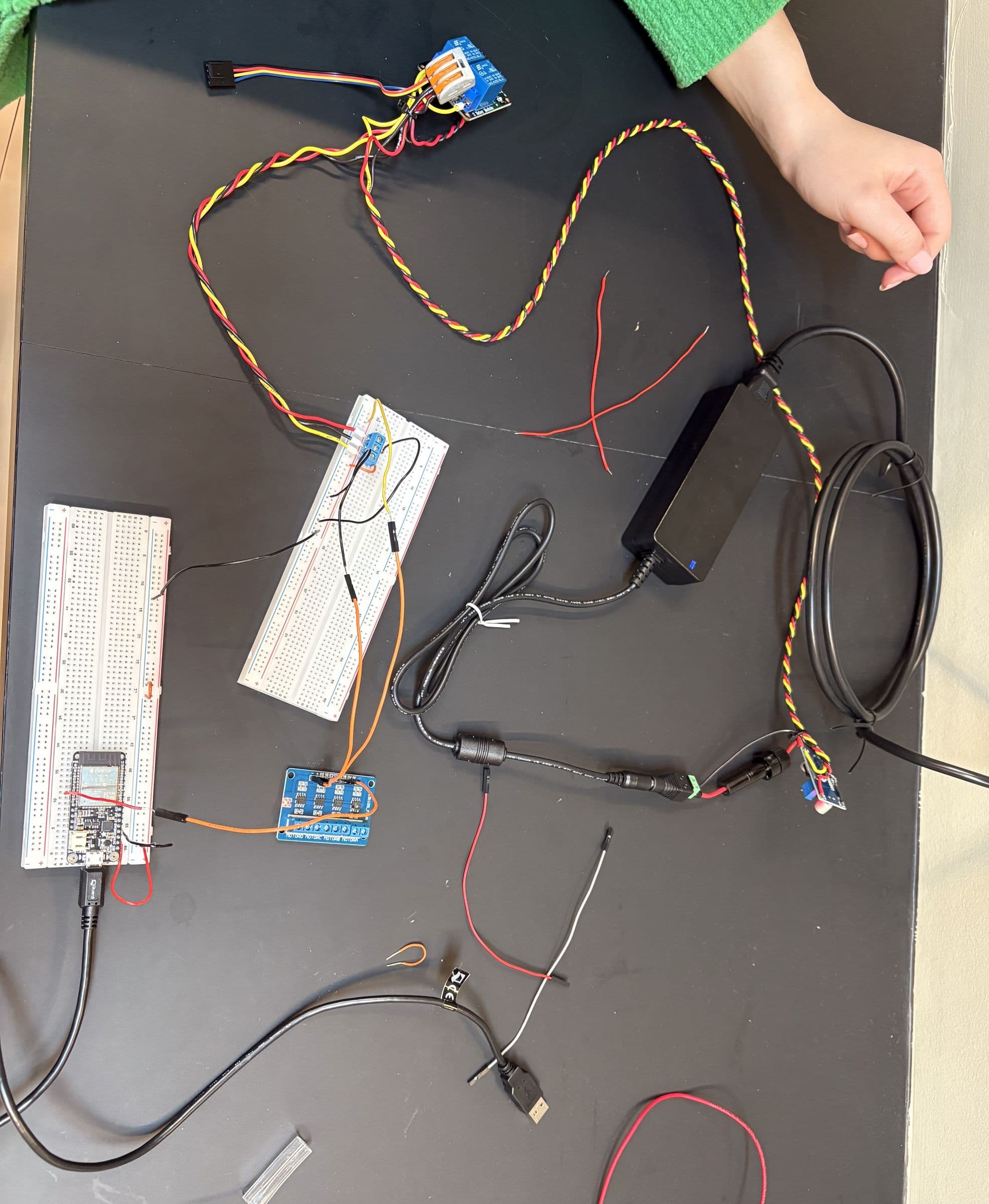 The breadboard electronics, microcontroller and power supply laid out on a bench